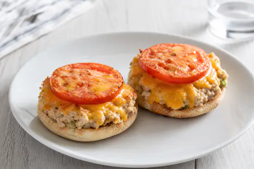 Open-faced tuna melts on toasted English muffins with melted cheddar and tomato slices