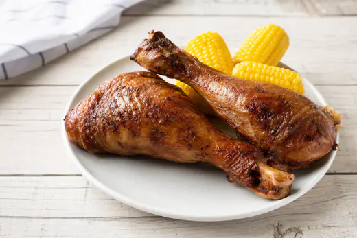Two crispy roasted turkey legs with browned skin on a white plate