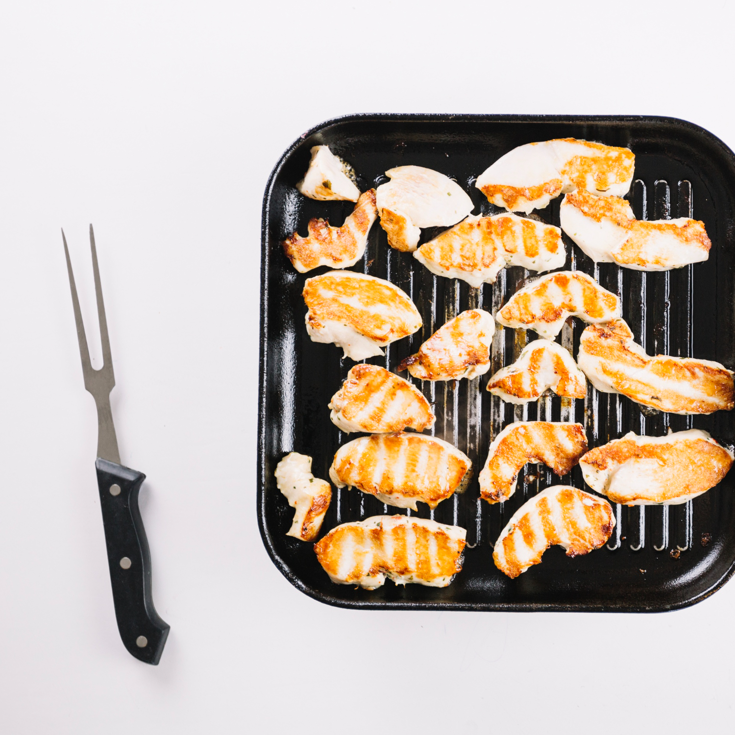 Golden brown chicken inner fillet in air fryer basket.