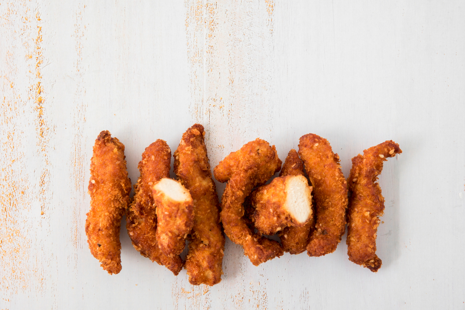 Crispy chicken strips in air fryer served with dipping sauce.