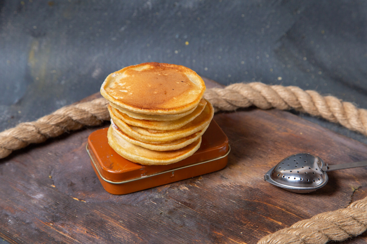 A stack of fluffy pancakes in air fryer served with syrup.